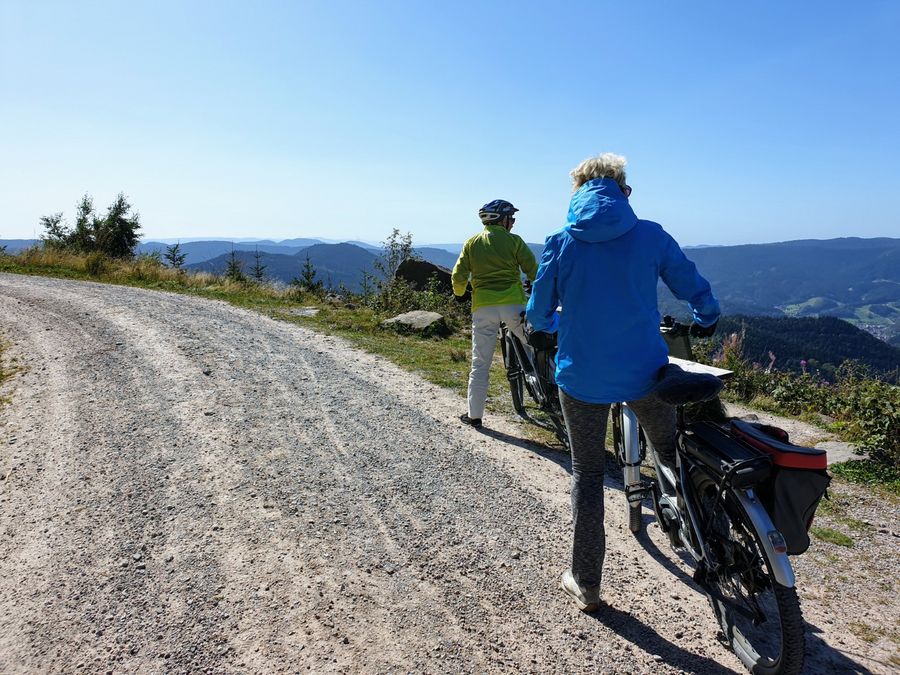 Zwei Fahrradfahrer stehen am Rand eines Schotterweges und genießen die Aussicht