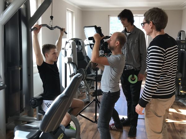 Ein Filmteam beim Mitarbeiter-Filmdreh in einem Fitnessstudio