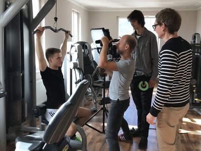 Ein Filmteam beim Mitarbeiter-Filmdreh in einem Fitnessstudio