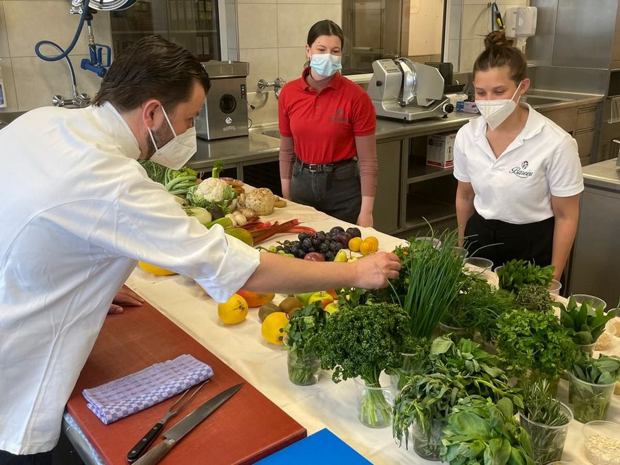 Koch des Hotels in Baiersbronn beim Erklären der Zubereitung von verschiedenen Obst und Gemüsesorten