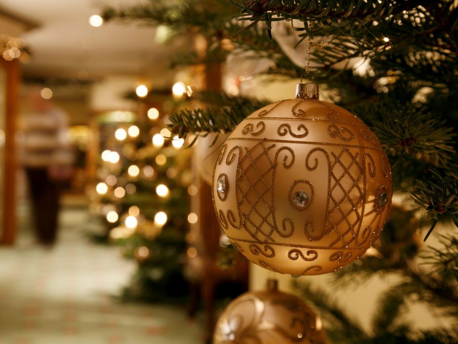 Detailaufnahme einer goldenen Christbaumkugel mit Glitzerverzierung