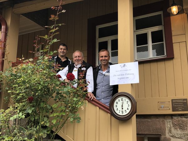 Drei Männer stehen auf einer Treppe des Morlokhofes