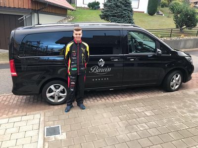 Marvin Andres aus Baiersbronn vor dem Shuttelbus des Luxushotels im Schwarzwald